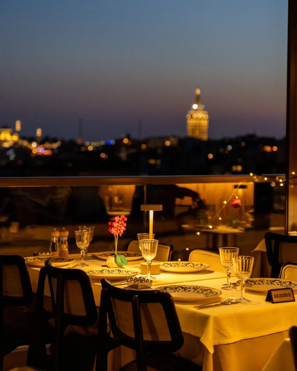 Arwin Roof'ta kurulmuş yemek masası ve İstanbul'un akşam manzarası