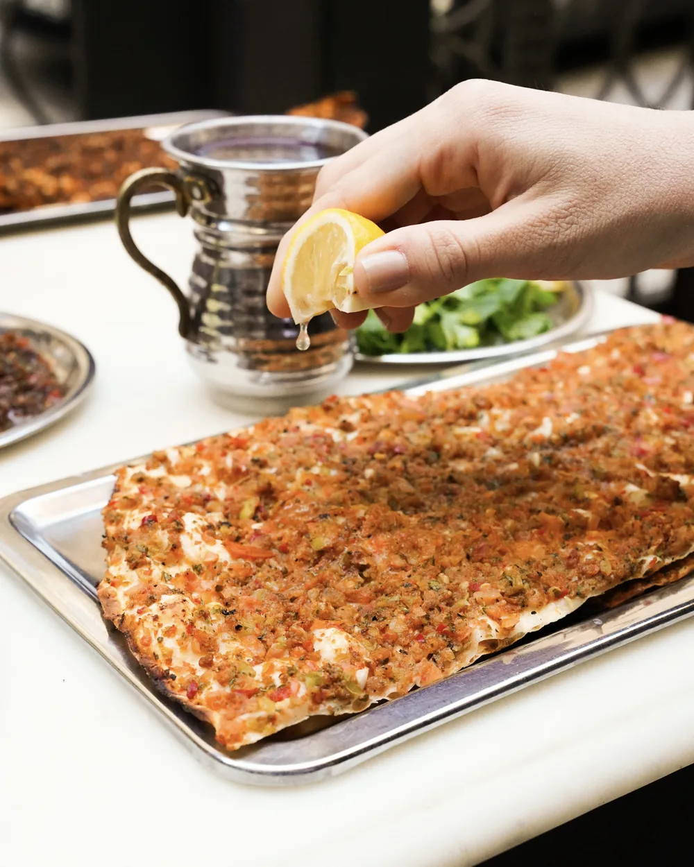 Baran'da taş fırın lahmacunu, limon ve taze yeşillikle servis ediliyor