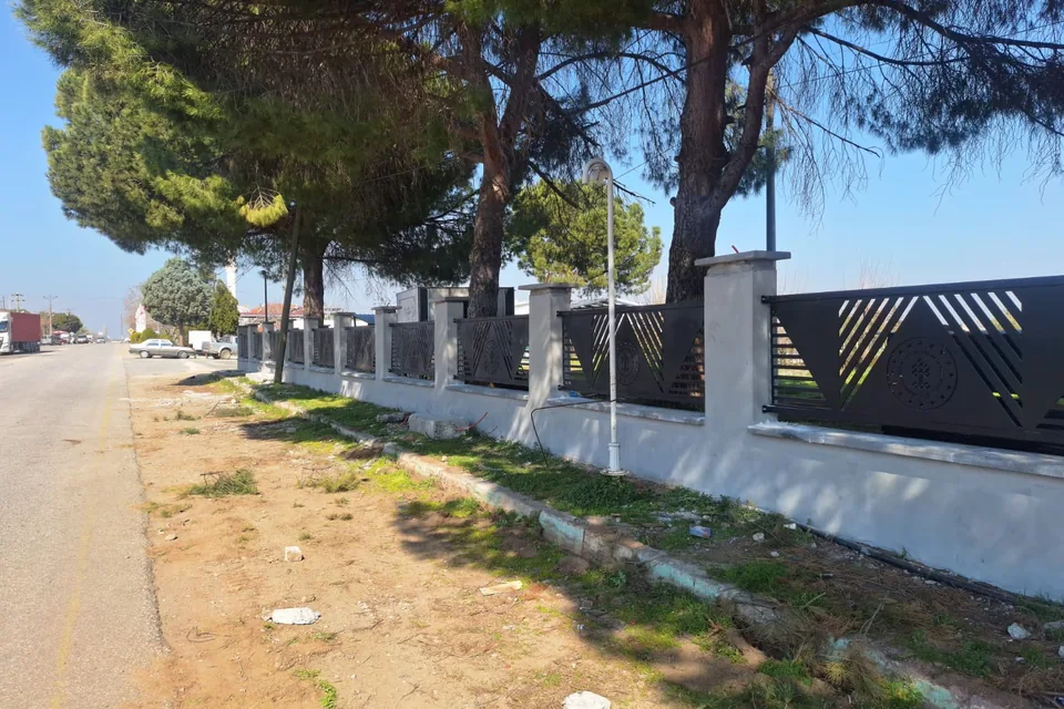 Sardes Antik Kenti çevresinde yol kenarı, çam ağaçları ve yeni korkuluklu duvar